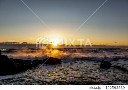 炎のように波と岩場が燃える荒波の神磯日の出風景 122598289