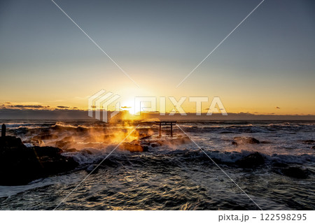 炎のように波と岩場が燃える荒波の神磯日の出風景 122598295