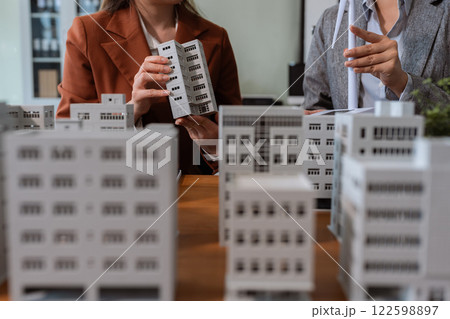 House model with agent asking costumer for contract to buy, get insurance or loan real estate or property. House model with agent asking costumer for contract to buy, get insurance or loan real estate or property. 122598897