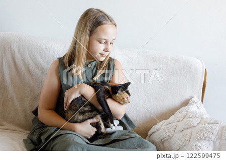Happy young girl and cat pet together at home. Friendship and care 122599475