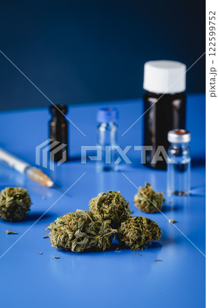 cannabis buds and flasks on a blue table 122599752