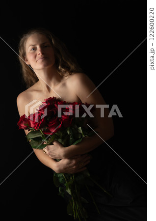 Sensual beautiful woman with bare shoulders and red roses on a dark studio background 122600220