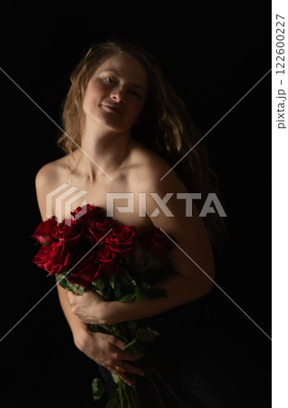 Sensual beautiful woman with bare shoulders and red roses on a dark studio background Sensual beautiful woman with bare shoulders and red roses on a dark studio background 122600227