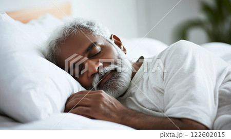 Tired senior man lying sleeping in white bed at home, sound asleep 122602015