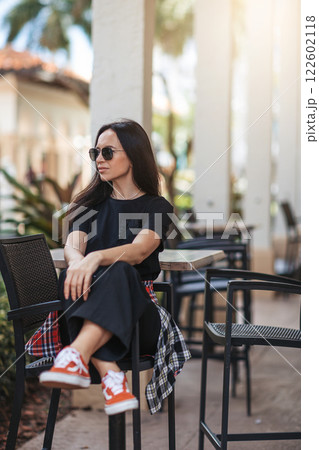 Young woman in outdoor cafe at summer day Young woman in outdoor cafe at summer day 122602118