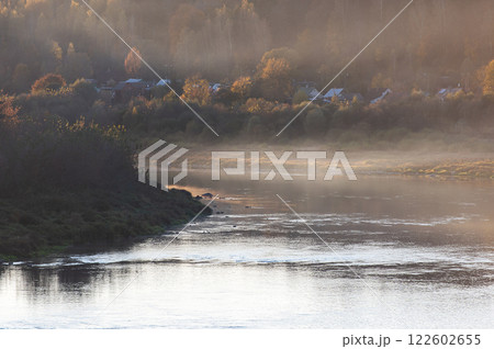 Roofs of houses of small town Kraslava in golden mist of sunset behind the river Daugava in Latvia 122602655