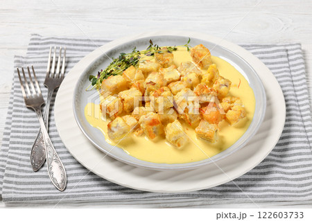 pollock cubes poached in cream saffron sauce 122603733