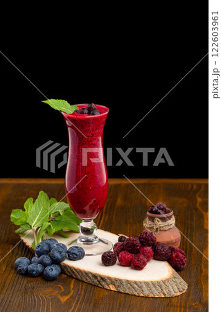 Glass of red currant berries fresh shake decorated with mint and blueberry isolated at white background. Glass of red currant berries fresh shake decorated with mint and blueberry isolated at white background. 122603961