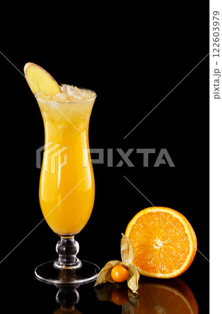 Closeup glass of fresh orange juice with ice decorated with ginger isolated at black background. Closeup glass of fresh orange juice with ice decorated with ginger isolated at black background. 122603979