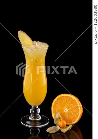 Closeup glass of fresh orange juice with ice decorated with ginger isolated at black background. 122603980