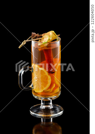 Closeup cup of xmas mulled wine with orange and cinnamon isolated at black background. 122604050