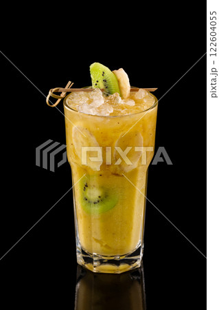 Closeup glass of fresh yellow banana smoothie with kiwi isolated at black background. 122604055