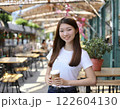 コーヒーを片手に微笑む女の子 122604130