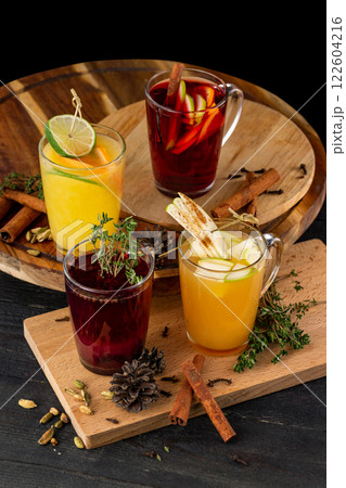 Vertical image of glasses of mulled wine with apple, orange, cinnamon at wooden table background. 122604216
