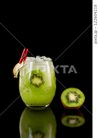 Closeup glass of healthy kiwi fresh juice with ice isolated at black background. Closeup glass of healthy kiwi fresh juice with ice isolated at black background. 122604219