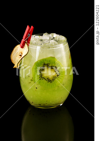 Closeup glass of healthy kiwi smoothie cocktail with ice isolated at black background. Closeup glass of healthy kiwi smoothie cocktail with ice isolated at black background. 122604221
