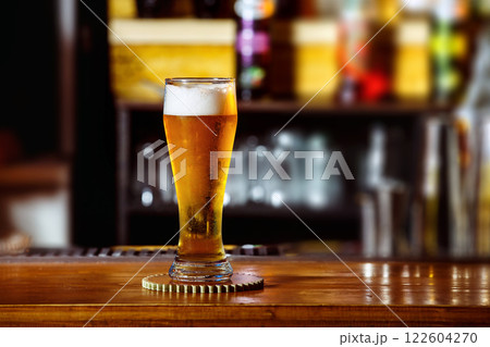 Closeup image of glass with golden unbottled light beer at bar background. Closeup image of glass with golden unbottled light beer at bar background. 122604270