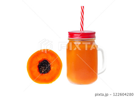 Closeup mug of orange papaya juice served with a straw and a half of papaya fruit isolated at white background. 122604280