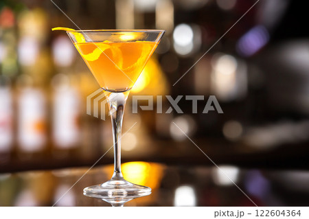 Fresh tall glass of tropical cocktail with rum and orange juice at bar counter background. 122604364