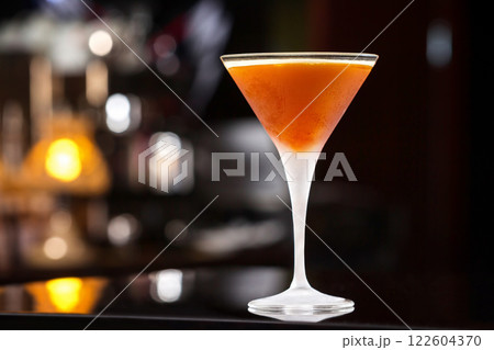Glass of orange cocktail with vodka, syrup and wine at bar background. 122604370