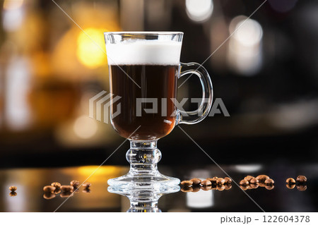 Closeup glass of irish coffee cocktail at bright bar counter background. Closeup glass of irish coffee cocktail at bright bar counter background. 122604378