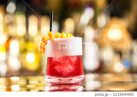Glass of special sex on beach cocktail decorated with cream and orange at colorful bar background. Glass of special sex on beach cocktail decorated with cream and orange at colorful bar background. 122604400