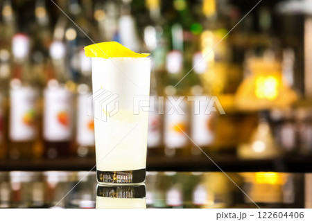 Closeup glass of gin fizz cocktail with lemon and whip eggwhite at bar cpunter background. Closeup glass of gin fizz cocktail with lemon and whip eggwhite at bar cpunter background. 122604406