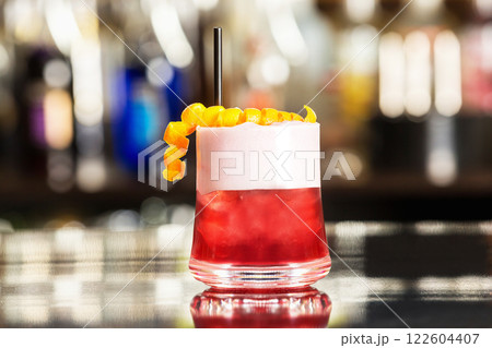 Glass of special sex on beach cocktail decorated with cream and orange at colorful bar background. 122604407
