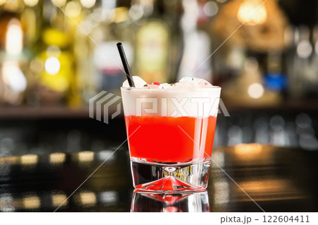 Closeup glass of special sex on beach cocktail decorated with cream at bar counter. Closeup glass of special sex on beach cocktail decorated with cream at bar counter. 122604411