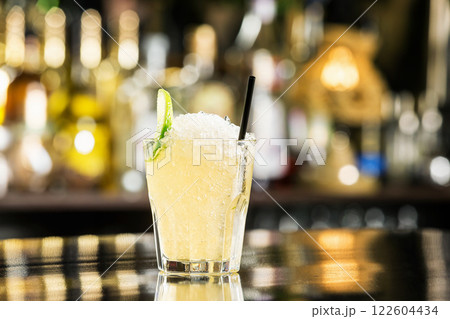 Closeup glass of mohito cocktail decorated with lime slice and crushed ice at bar background. 122604434
