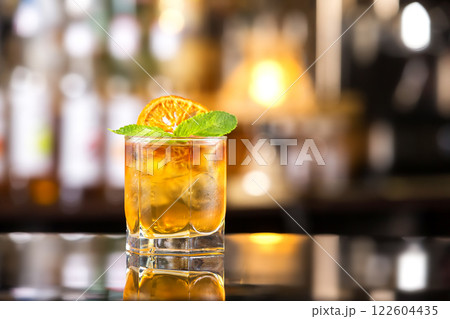 Closeup glass of mai tai cocktail decorated with orange chips and mint at bar counter background. Closeup glass of mai tai cocktail decorated with orange chips and mint at bar counter background. 122604435