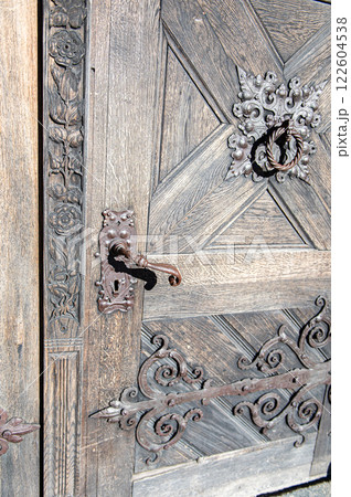 Old  wooden door set in a medieval stone wall 122604538