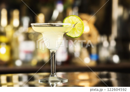 Closeup glass of margarita cocktail decorated with lime at bar background. 122604592