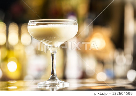 Closeup glass of milk liquor based cocktail at bright bar counter background. Closeup glass of milk liquor based cocktail at bright bar counter background. 122604599