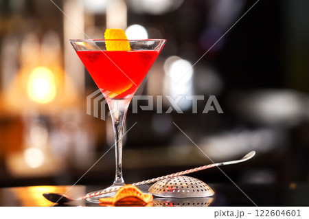 Closeup glass of Manhattan cocktail decorated with orange at bar counter background. Closeup glass of Manhattan cocktail decorated with orange at bar counter background. 122604601