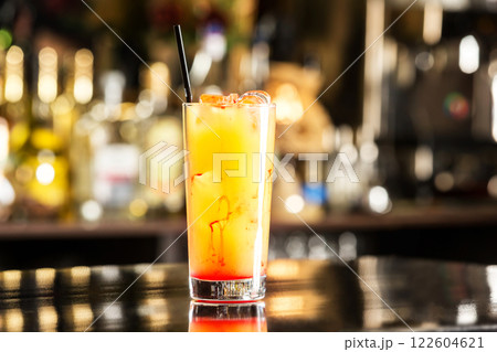 Closeup glass of tequila sunrise cocktail at bar background. Closeup glass of tequila sunrise cocktail at bar background. 122604621