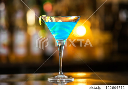 Closeup glass of blue lagoon cocktail decorated with lime at festive bar counter background. Closeup glass of blue lagoon cocktail decorated with lime at festive bar counter background. 122604711