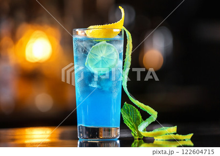 Closeup glass of pacific ocean cocktail decorated with lime at festive bar counter background. 122604715