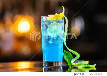 Closeup glass of blue lagoon cocktail decorated with lime at festive bar counter background. 122604716