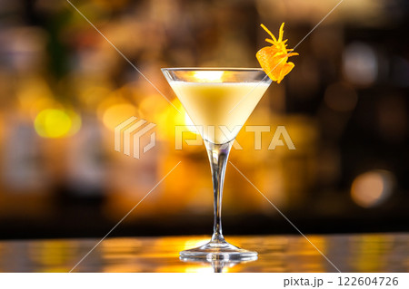 Closeup glass of egg liquor decorated with orange at bright bar counter background. 122604726