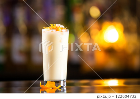Closeup glass of milk shake cocktail at bright bar counter background. Closeup glass of milk shake cocktail at bright bar counter background. 122604732