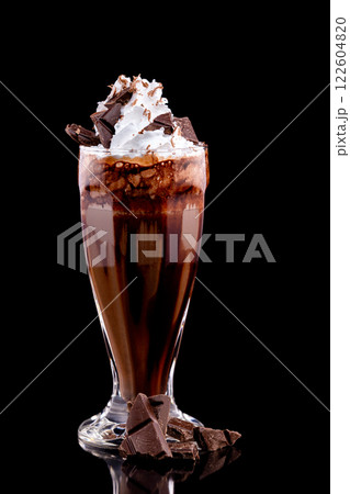 Closeup glass of chocolate milk shake decorated with whipped cream isolated at black background. 122604820