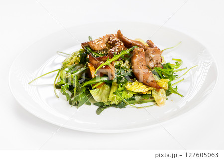 Closeup image of roasted duck at plate with green salad isolated at white background. Closeup image of roasted duck at plate with green salad isolated at white background. 122605063