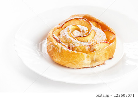 Sweet rose style twisted cake of pastry puff on plate isolated at white background. Sweet rose style twisted cake of pastry puff on plate isolated at white background. 122605071
