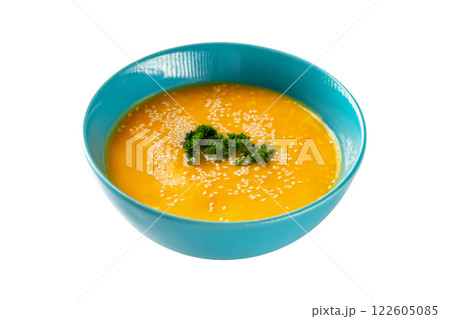 Closeup bowl of pumpkin soup decorated with parsley and sesame isolated at white background. Concept of healthy lifestyle. Closeup bowl of pumpkin soup decorated with parsley and sesame isolated at white background. Concept of healthy lifestyle. 122605085