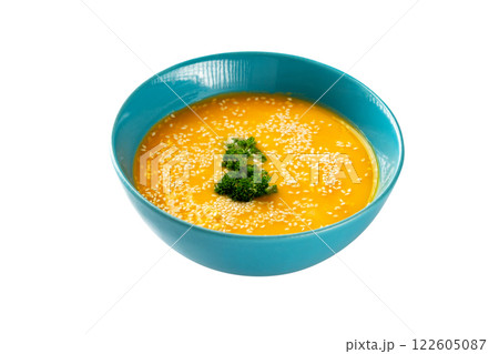 Closeup bowl of pumpkin soup decorated with parsley and sesame isolated at white background. Concept of healthy lifestyle. 122605087