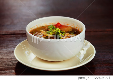 Bowl of fresh spicy hot thai soup Tom Yum at wooden table background. 122605091