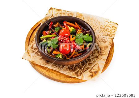 Pan of grilled vegetables served at a paper on wooden board isolated at white background. Pan of grilled vegetables served at a paper on wooden board isolated at white background. 122605093