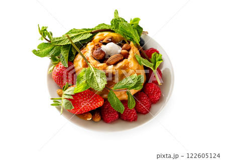 Closeup plate of baked apple served with strawberries, raspberries, nuts, mint and caramel isolated at white background. Concept of healthy lifestyle. Closeup plate of baked apple served with strawberries, raspberries, nuts, mint and caramel isolated at white background. Concept of healthy lifestyle. 122605124