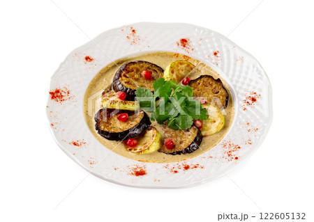 Plate of grilled eggplant and squash slices served with sauce isolated at white background. Plate of grilled eggplant and squash slices served with sauce isolated at white background. 122605132